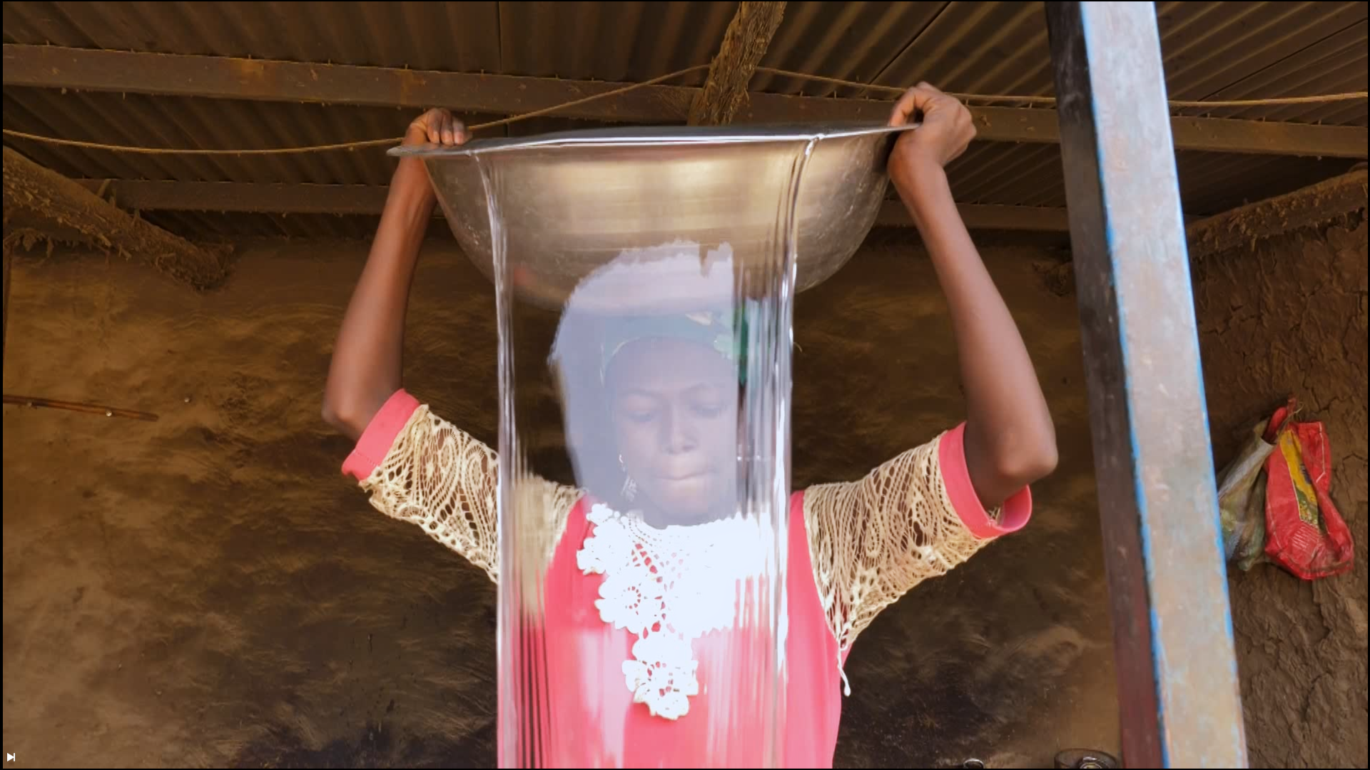 A woman holding a metal basin in a scene from Amchilini, Choose Me