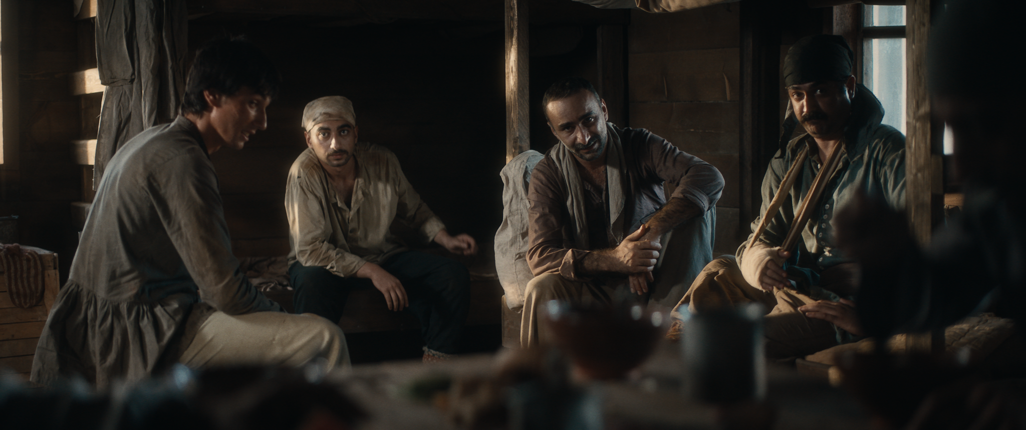 Men gathered in a dim interior in Taghiyev: Oil