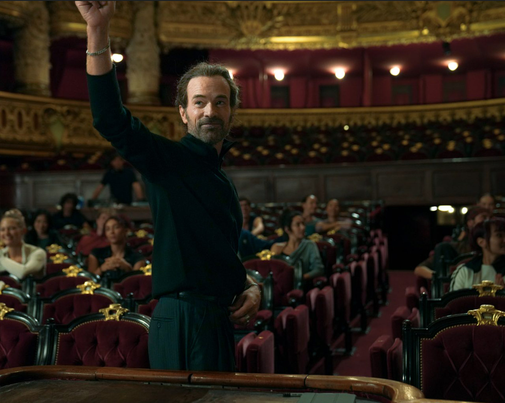 A man standing before an audience in The Phantom of the Opera (Le Fantôme de l'Opéra)
