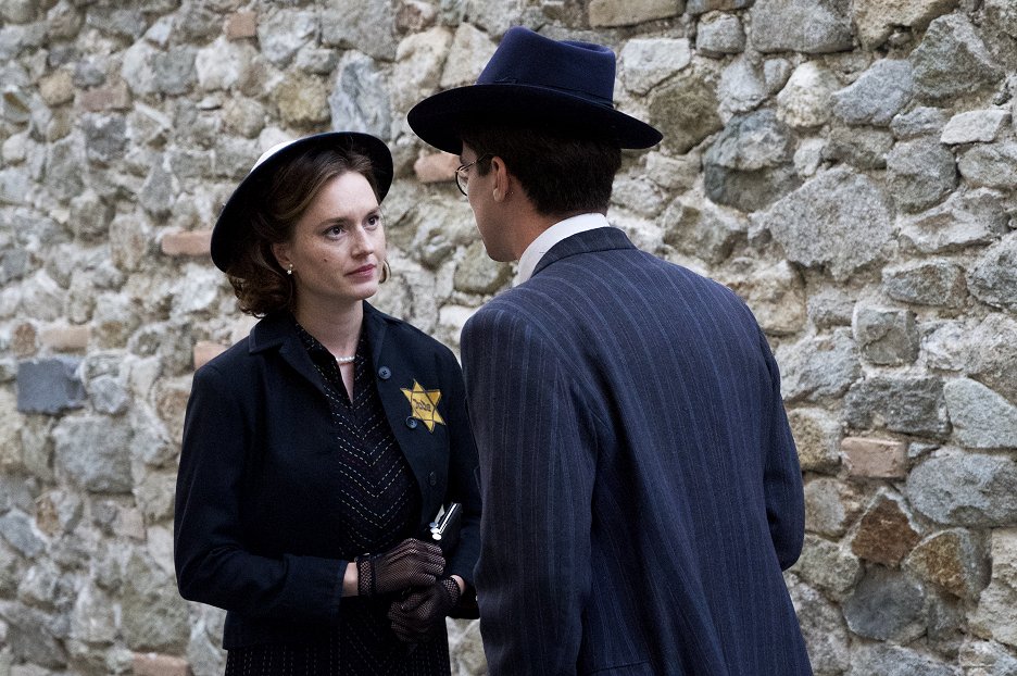 Two characters speaking by an old stone wall in The Dormant Account