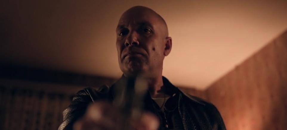A tense interior scene featuring a man in shadow