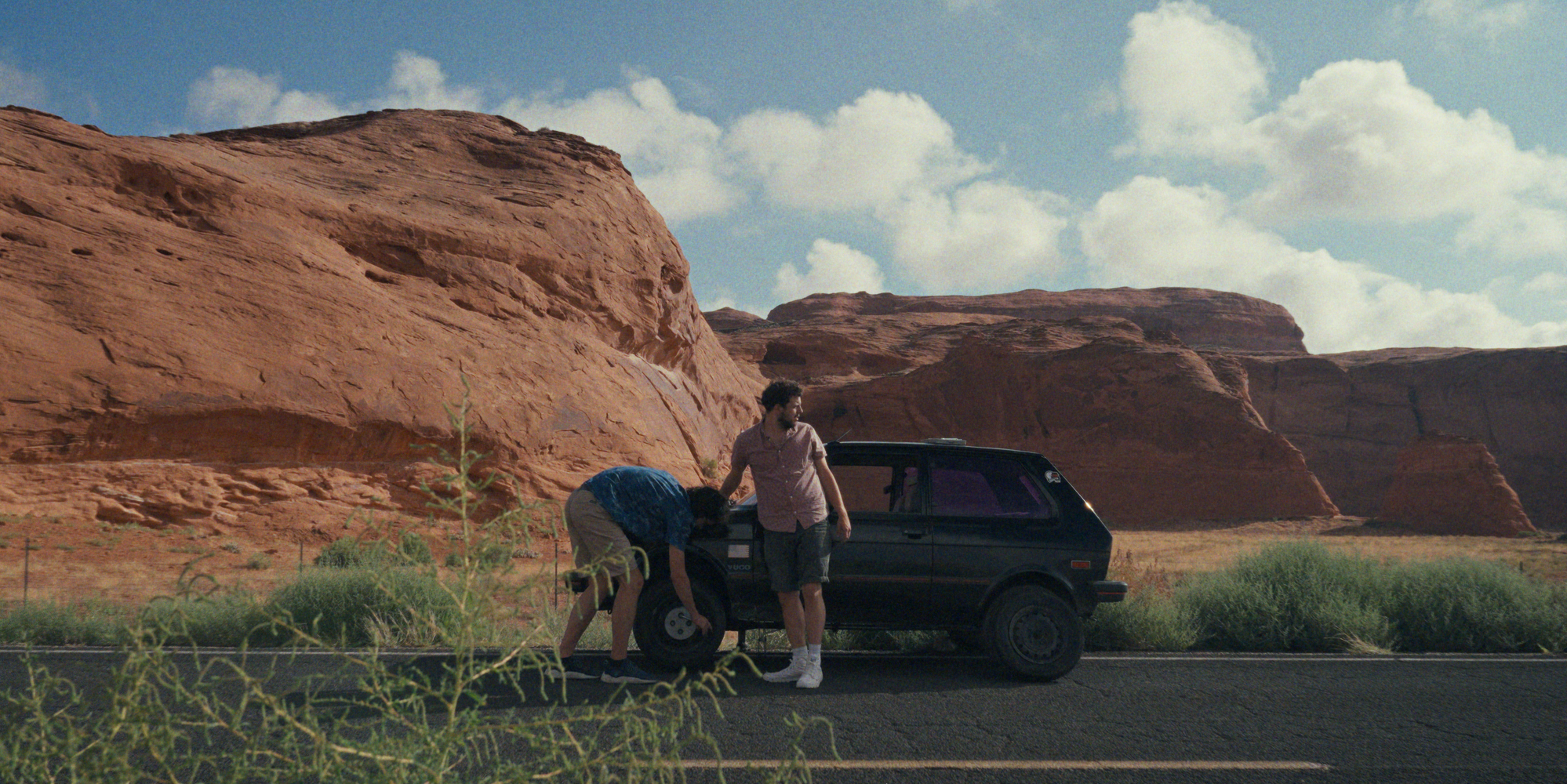 The Yugo parked in a desert landscape on the American road trip