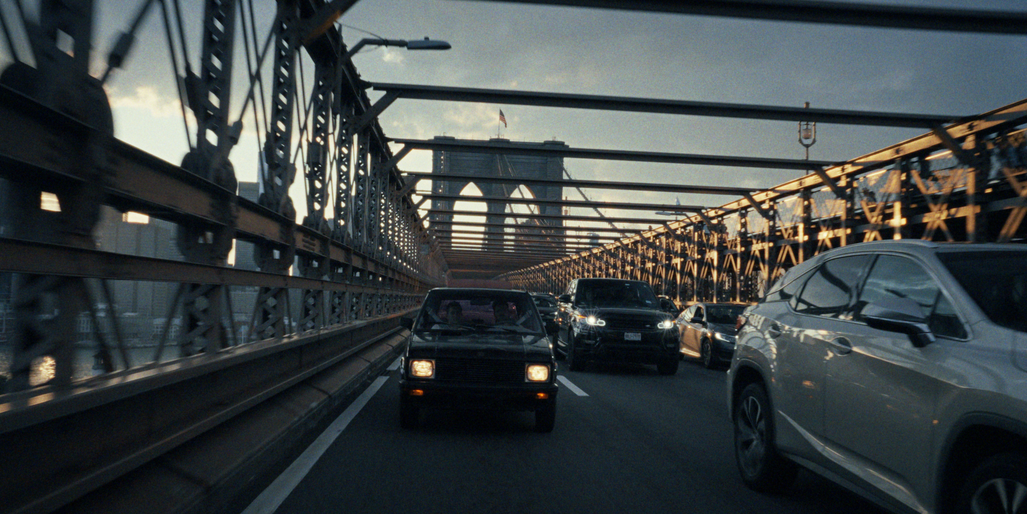 A Yugo driving across a steel bridge in the United States